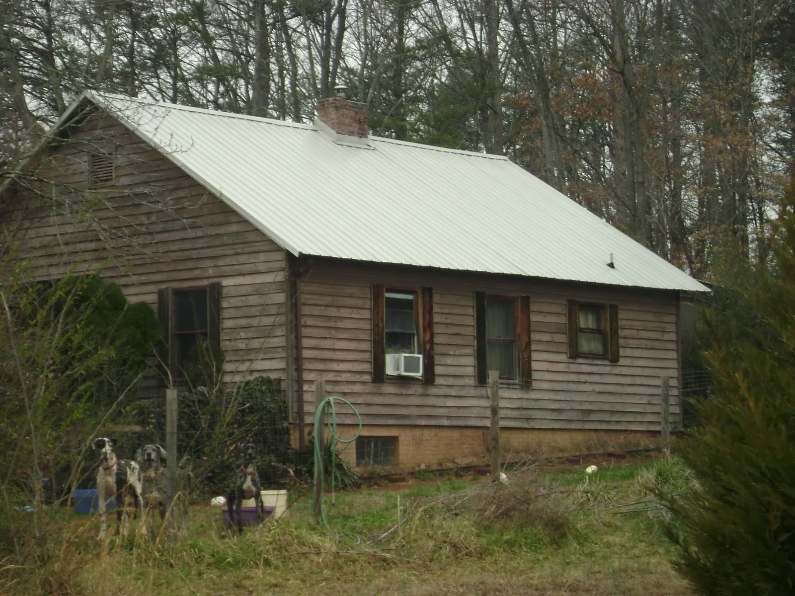 White metal roof on an old wood sided farmhouse, from a Metal Roof Installation job in Wingate